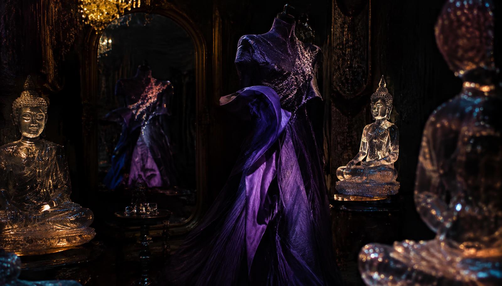 An opulent dark room filled with glowing crystal antique Buddha statues, a surreal avant-garde purple haute couture garment illuminated under dramatic spotlight, hidden embroidery faintly glowing in a vintage mirror reflection, dark moody cinematic photography.